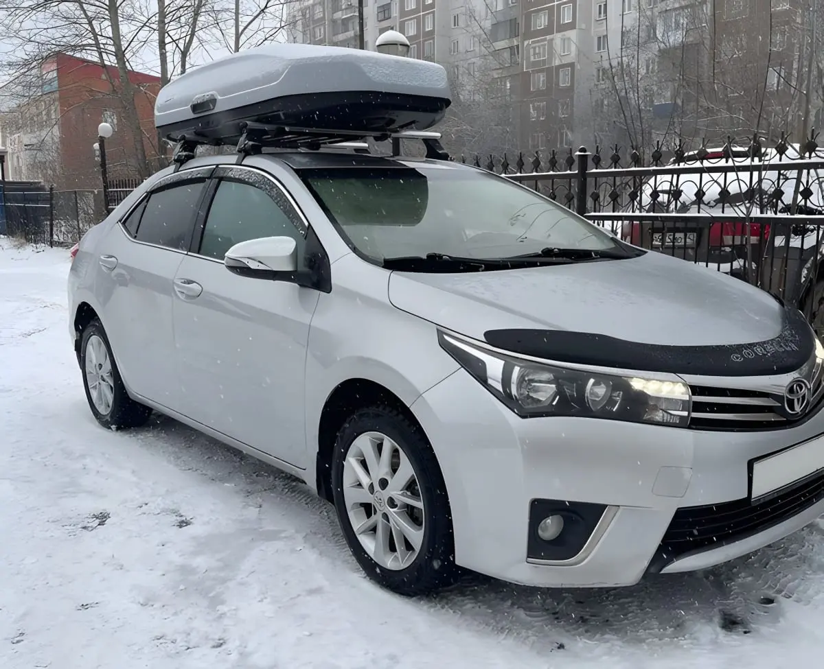 Легковой автомобиль Toyota Corolla с боксом на крыше